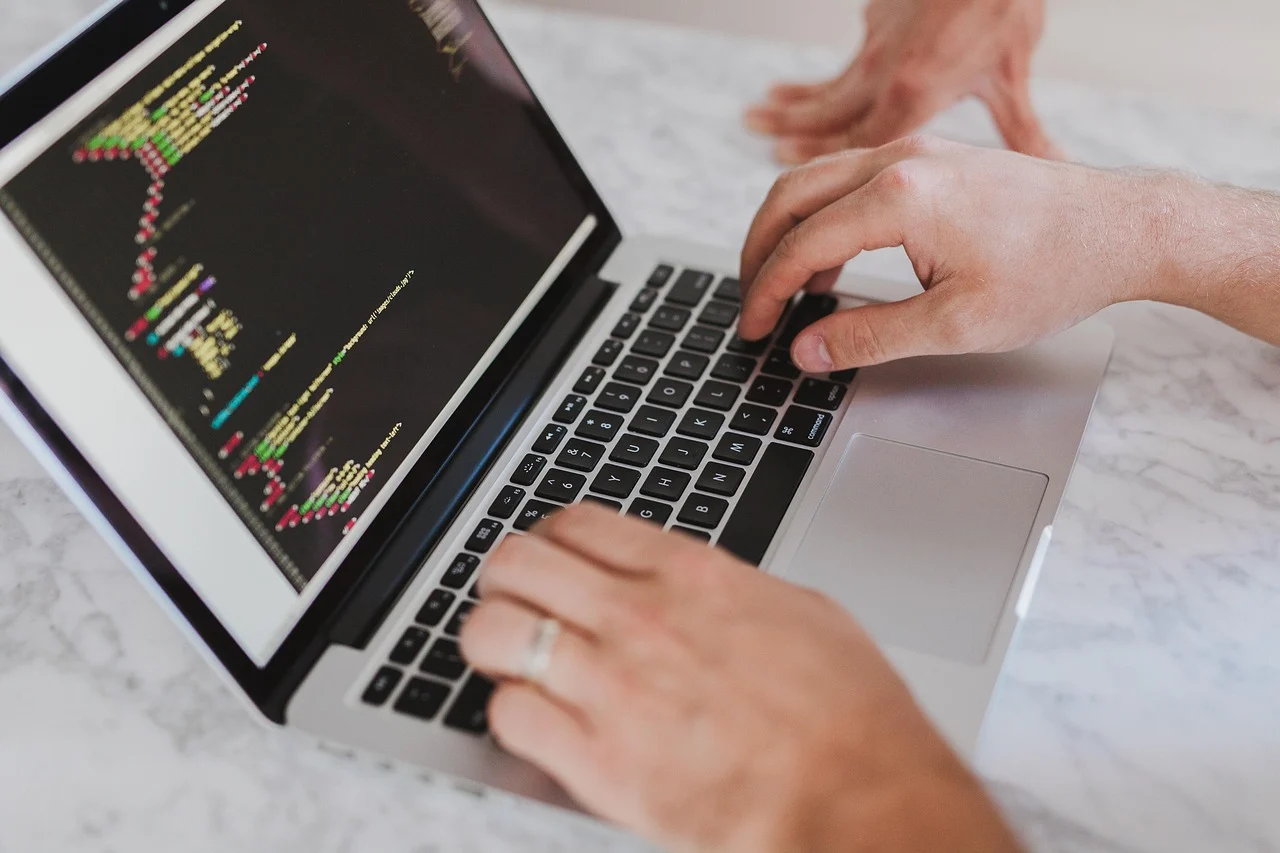 Web designer building a website layout on a laptop at a desk